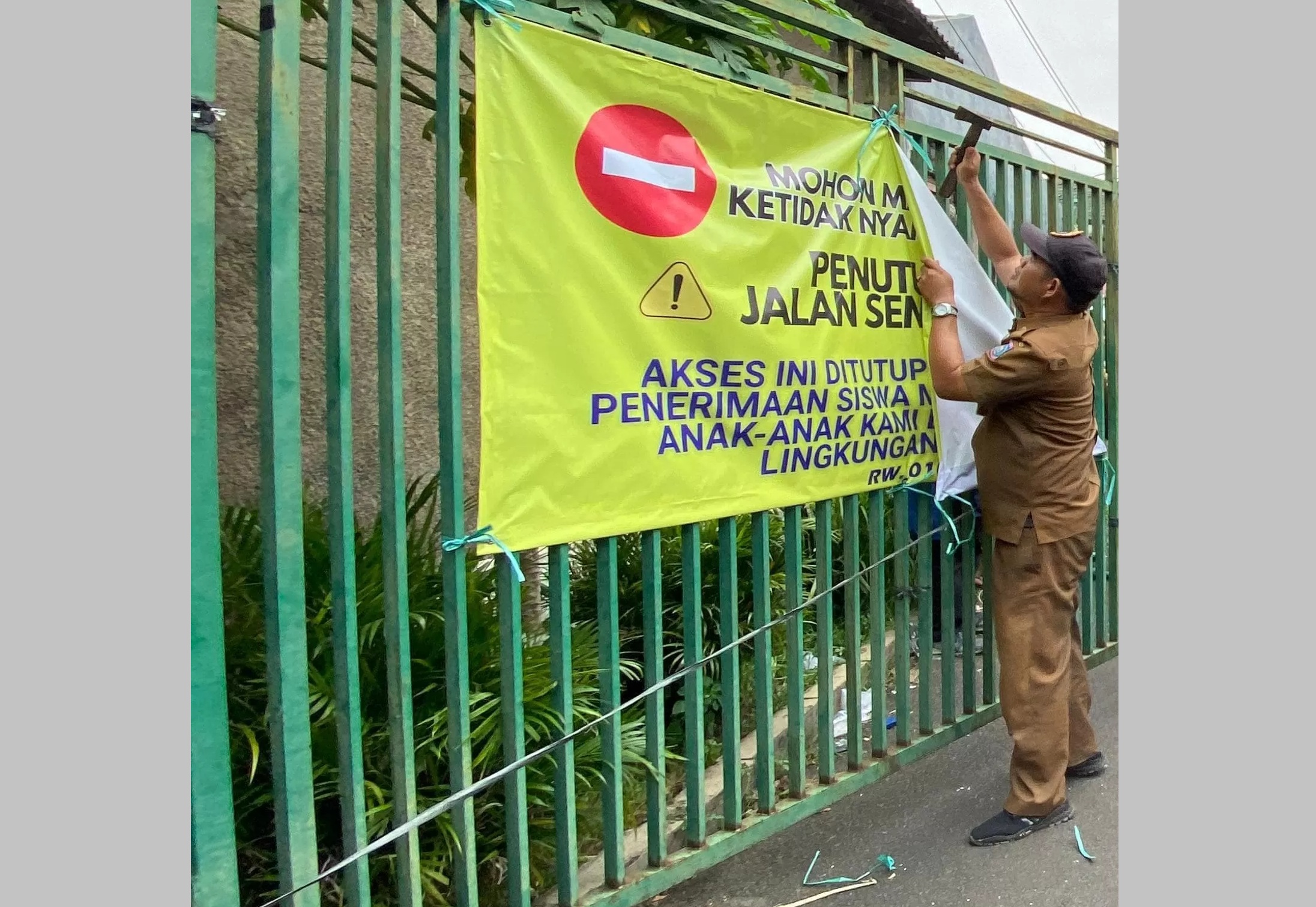 
Petugas saat menurunkan spanduk pemblokiran sekolah di Tangsel. 

